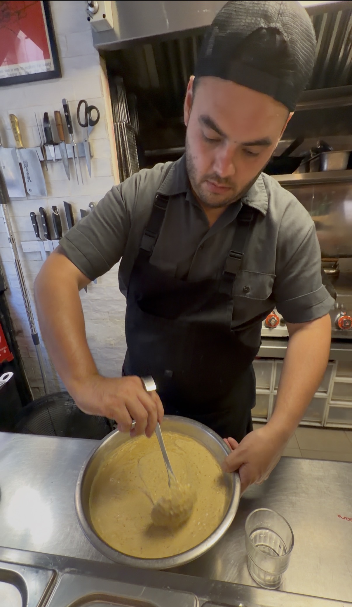 El socio chef mezclando la salsa en una olla