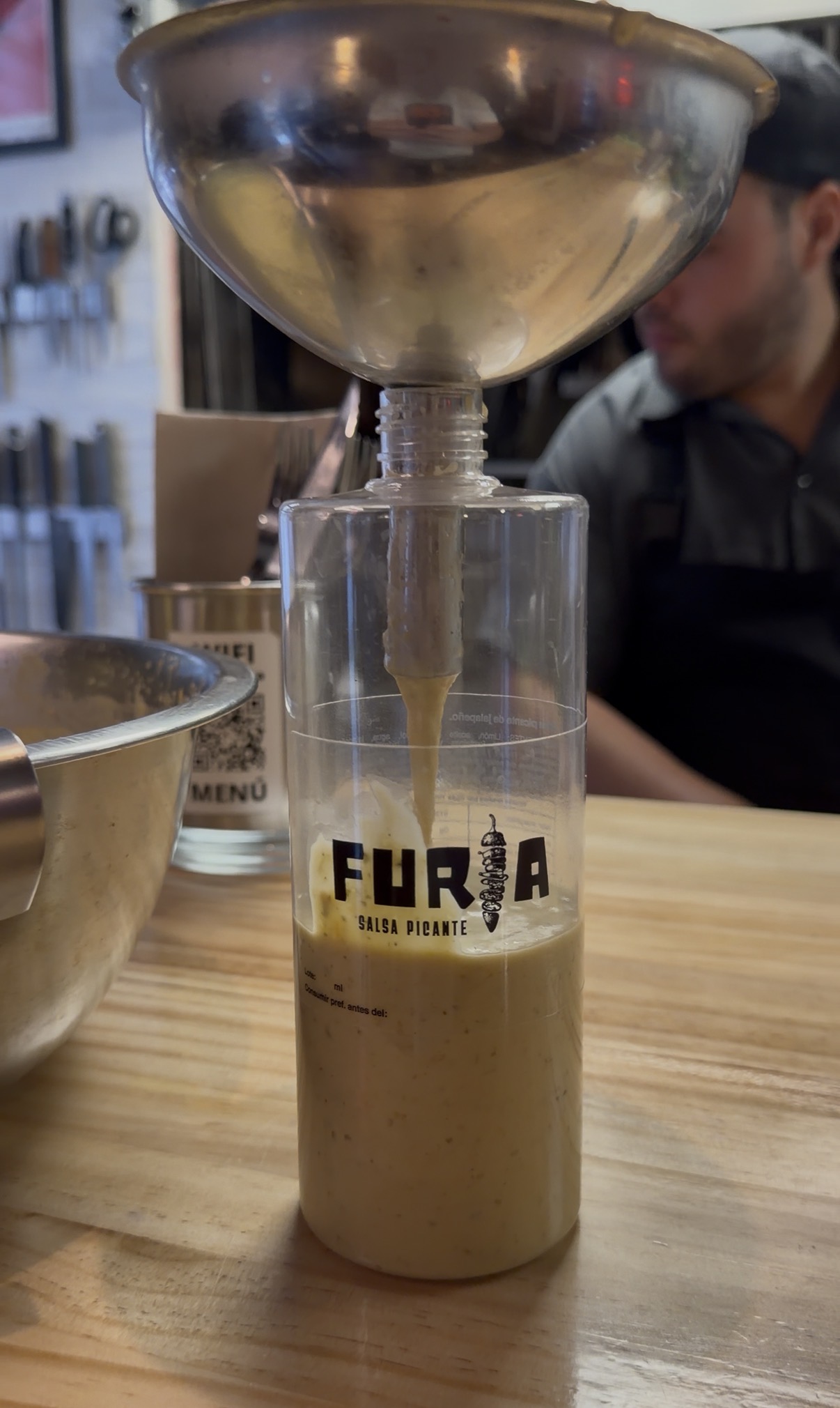 Embudo y botella sobre la barra de madera
